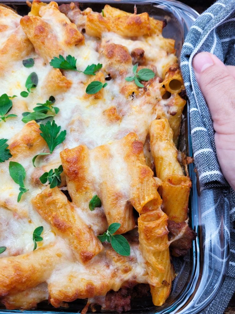 Removing pasta al forno from the oven.