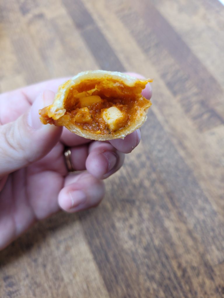 Microwaved pizza roll with a bite taken out